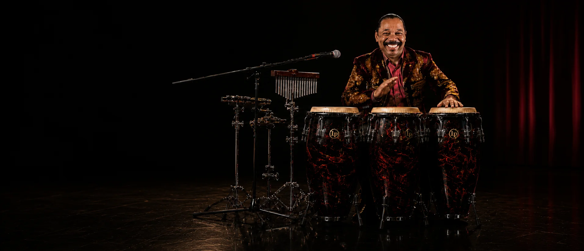 Victor Orlando performing on congas on a dark concert stage